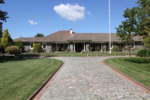 a house with a stone driveway in front of it at Historic Merryville Homestead in Murrumbateman