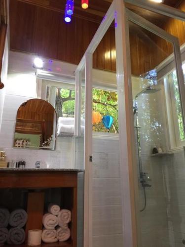 a bathroom with a shower and a sink with towels at Khamy Riverside Villa in Hoi An