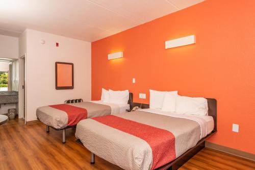 two beds in a room with an orange wall at Motel 6-Kingsport, TN in Kingsport