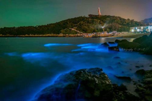 a large body of water with a lighthouse in the background at GOD’S Queen Esther in Nangan