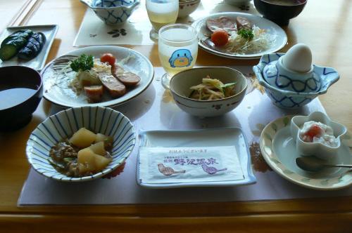 a table with plates of food on a table at Fureai No Yado Yasuragi in Nozawa Onsen
