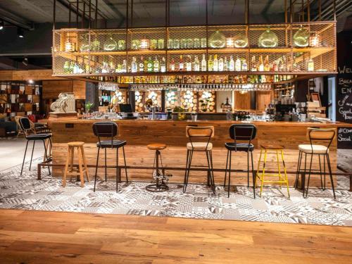a bar with six chairs and a bar counter at Novotel Avignon Nord in Sorgues