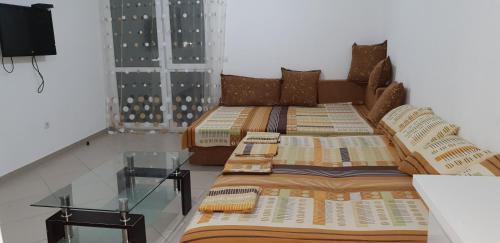 two beds in a room with a glass table at Aparmani Family 1 in Sutomore
