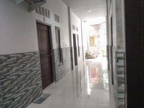 a hallway of a building with a door and a tile floor at Penginapan Artha in Praya