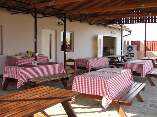 a patio with red and white tables and benches at Coffeecamp-Kovilj in Kovilj
