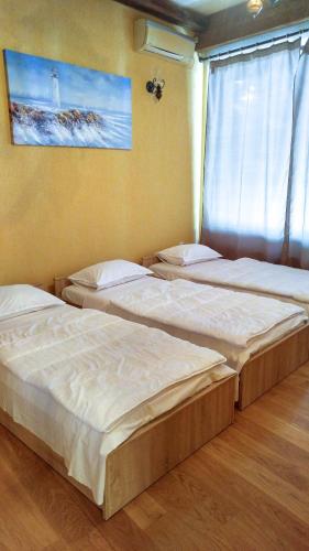 three beds in a room with a window at DCK Apartments in Kostrena