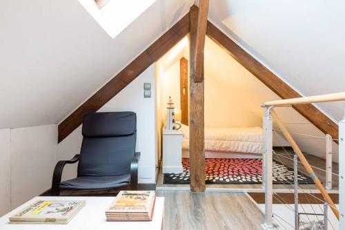 een zolderkamer met een stoel en een bed bij Duplex in Saint-Malo