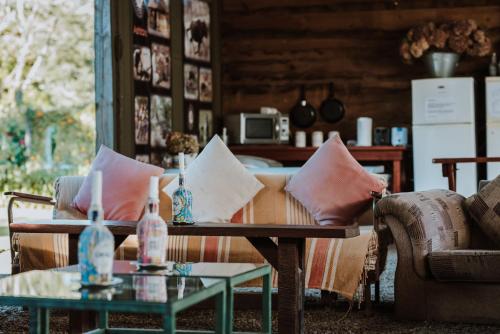 a living room with a couch and a table with pillows at The Village Lodge in Stormsrivier