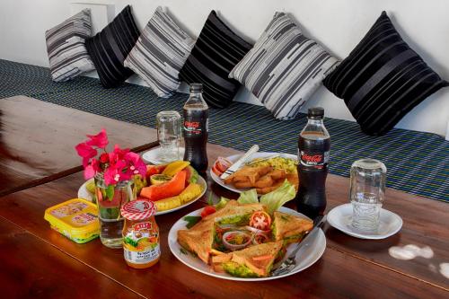 a table with two plates of food and two bottles of soda at Aqua Blue in Arugam Bay