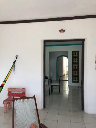 a living room with a white wall and a table and chairs at Casa Colonial Centro in Mérida