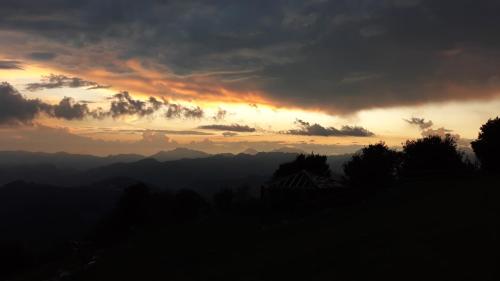 a sunset in the mountains with a cloudy sky at Resort Monte Poieto in Aviatico