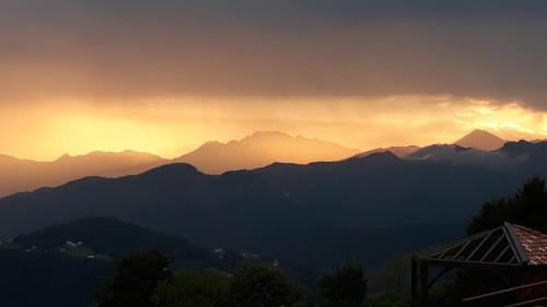 a sunset over a mountain range with the sun setting at Resort Monte Poieto in Aviatico