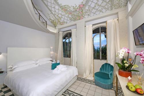 una camera bianca con un letto e una finestra di La Ribezza Boutique Hotel - Adults Only a Monforte dʼAlba