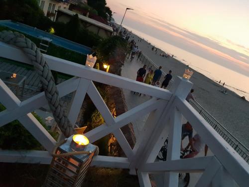 a group of people walking on the beach at sunset at Dom Przy Plaży in Sarbinowo