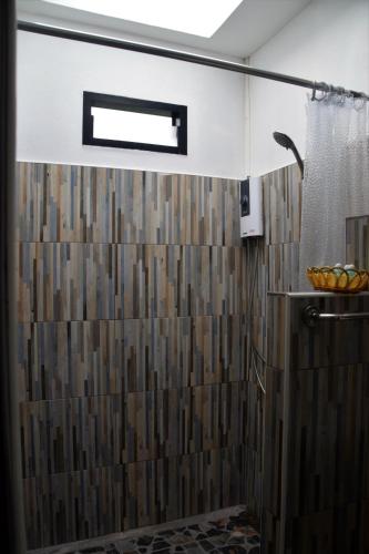 a bathroom with a shower with a wooden wall at Nubdao Resort&Restaurant in Nong Prue