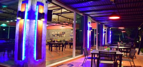 een restaurant met tafels en stoelen en paarse verlichting bij Nubdao Resort&Restaurant in Nong Prue