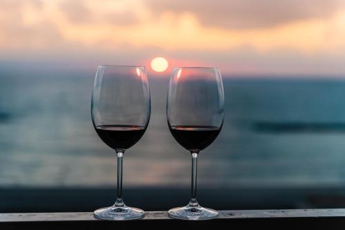 Sea view apartment suite في تل أبيب: كأسين من النبيذ الأحمر يجلسون على حافة