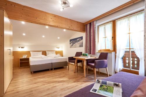 um quarto de hotel com uma cama e uma mesa em Landhaus Strolz em Sankt Anton am Arlberg