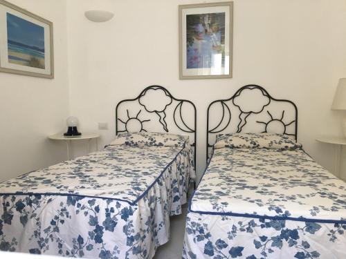 a bedroom with two beds with blue and white sheets at Cottage in Panarea in Panarea