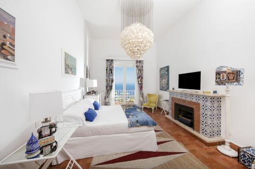 a white bedroom with a bed and a fireplace at Casa Marta Capri in Capri