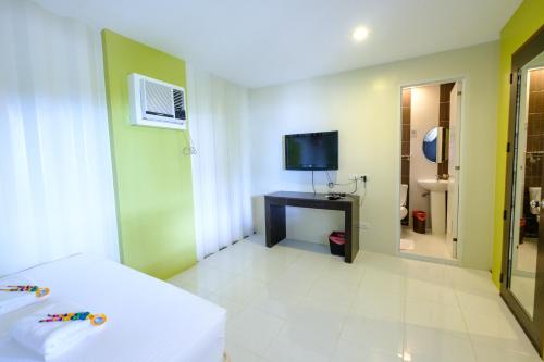 a hotel room with a bed and a television at Anika Island Resort in Bantayan Island