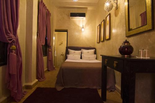 una camera da letto con un letto e un tavolo in una stanza di Riad Hermès a Marrakech
