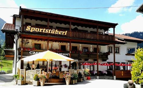 a building with an umbrella in front of it at Appartements Sportsüberl in Berwang
