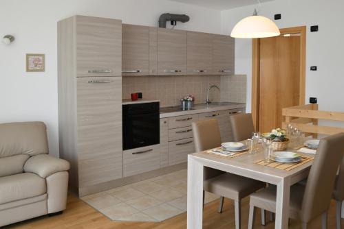 eine Küche und ein Esszimmer mit einem Tisch und Stühlen in der Unterkunft Apartment Gli Ulivi - Tremezzina in Tremezzo