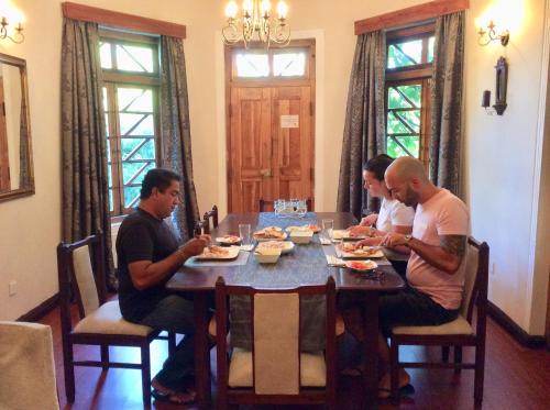 a group of people sitting around a table eating food at Hotel Mount Pleasant in Bandarawela