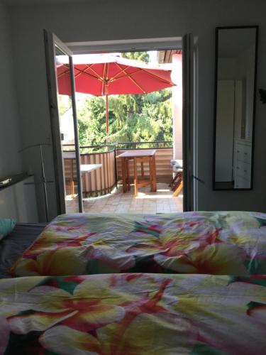 een slaapkamer met een bed en een open deur met een paraplu bij Loft Seeblick Überlingen in Überlingen