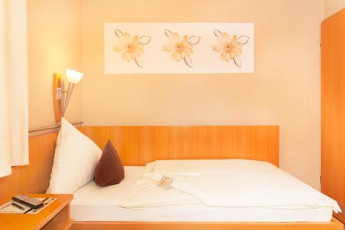 a bedroom with a white bed with flowers on the wall at Moselhaus Weiskopf in Bernkastel-Kues