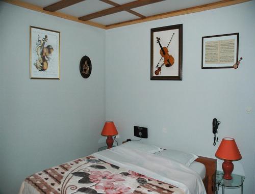 a bedroom with a bed and three pictures on the wall at B&B Mirage in Frécourt