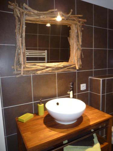 une salle de bain avec un lavabo blanc et un miroir dans l'établissement Chambres d'Hôtes Les Potiers, à Sens-Beaujeu