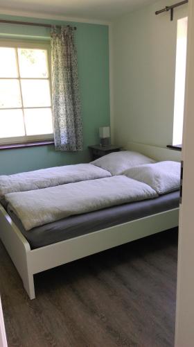 a bed in a bedroom with a window at Ferienwohnung Böttcher in Putbus