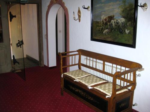 a room with a wooden bench and a painting on the wall at Panoramahotel Karwendelhof in Wallgau