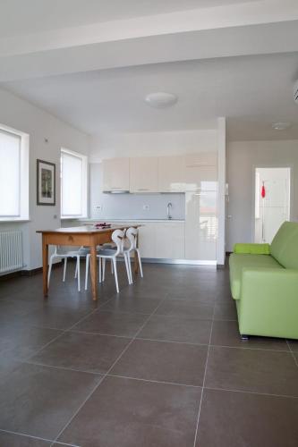 a living room with a table and a green couch at Casa Rosa dei Venti in Nago-Torbole