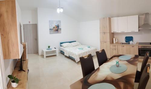 Habitación con cocina, mesa y cama en Apartman Andrea en Zadar