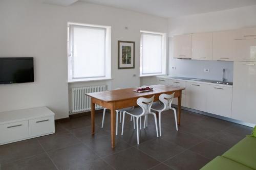 a kitchen with a wooden table and two stools at Casa Rosa dei Venti in Nago-Torbole