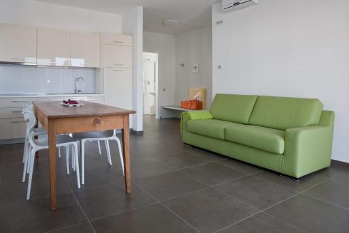 a living room with a green couch and a table at Casa Rosa dei Venti in Nago-Torbole