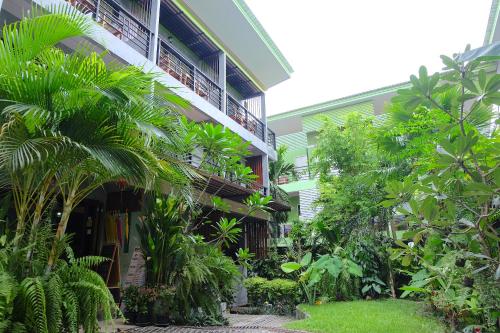 une cour d'un bâtiment avec des arbres et des plantes dans l'établissement Blue Wave House, à Koh Tao