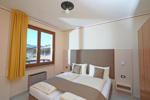 a bedroom with two beds and a window at Hotel Residence La Pertica in Tremosine Sul Garda