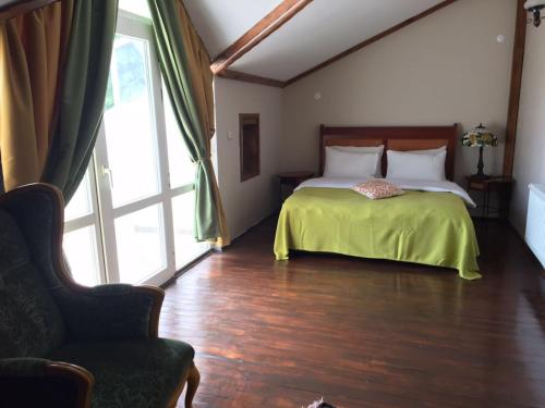 um quarto com uma cama com um cobertor verde e uma cadeira em Villa SD Sapanca em Sapanca