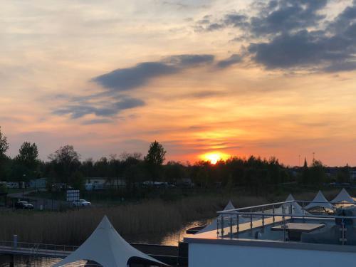 a sunset over a body of water with the sun setting at Hausboot Harmonie in Bitterfeld