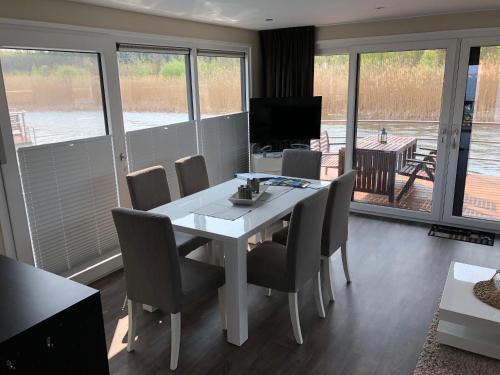 a dining room with a white table and chairs at Hausboot Harmonie in Bitterfeld