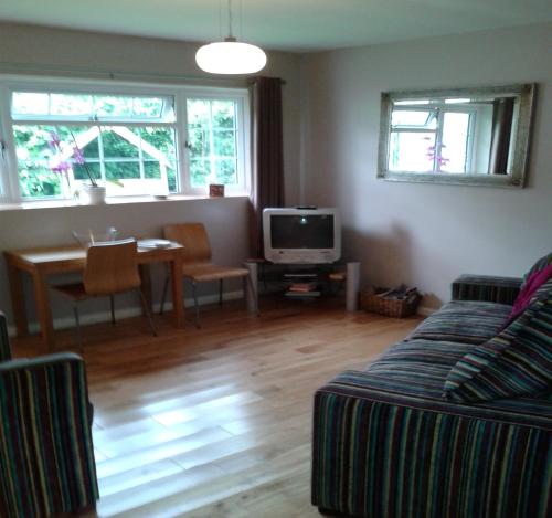 sala de estar con sofá y mesa en Railway Cottage en Cardiff