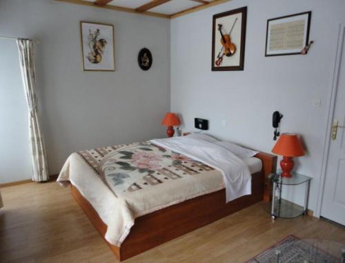 a bedroom with a bed with two lamps and two tables at B&B Mirage in Frécourt