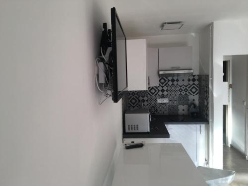 une cuisine avec des placards blancs et un comptoir blanc dans l'établissement Studio Face Mer, à Le Touquet-Paris-Plage