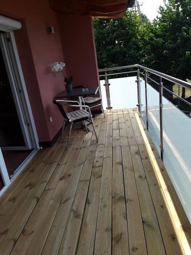 a wooden deck with a table and a chair on a balcony at Mediterraneo in Hülben