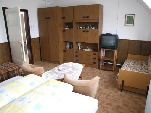 een woonkamer met een tafel en een televisie bij Révész Vendégház in Harkány