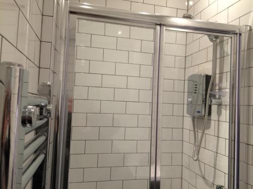een douche met een telefoon in de badkamer bij The Cwtch in Cardiff